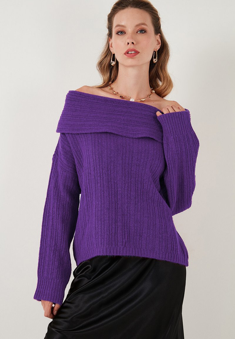 Maglione viola a coste off-the-shoulder con maniche lunghe, tessuto texture e scollatura ampia, abbinato a una gonna nera in satin.