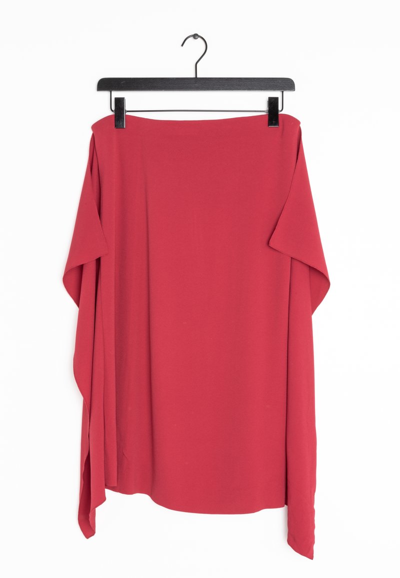 Jupe rouge asymétrique suspendue sur un cintre à pinces noir sur fond blanc.
