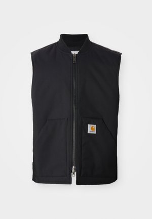 Vesta fără mâneci, de culoare neagră, cu guler înalt, fermoar frontal, două buzunare frontale și un patch cu logo pătrat pe buzunarul stâng. Textură de material neted.