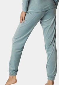 Lichtblauwe fleece pyjamabroek met een elastische tailleband en boorden, voorzien van een zachte textuur en een relaxte pasvorm, ideaal voor comfort.