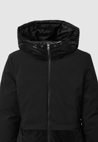 Giacca invernale nera imbottita con colletto alto e cappuccio regolabile, dotata di chiusura centrale con zip.