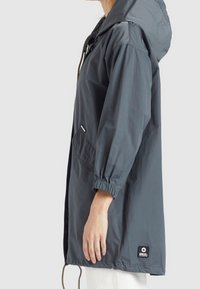 Ciemnoszara, lekką kurtkę z kapturem, elastycznymi mankietami i bocznymi kieszeniami. Zawiera metkę marki na dolnym obszyciu.