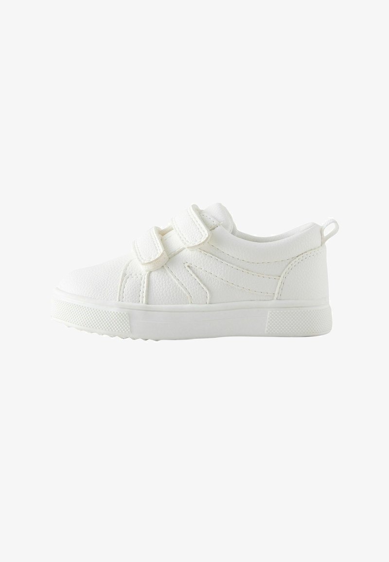 Baskets blanches pour enfants avec deux brides Velcro réglables, semelle texturée et languette au talon, montrées de profil.