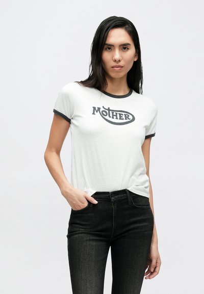 Ανοιχτό γκρίζο t-shirt με μαύρο λαιμόκοψη και το γράφημα «MOTHER» στο μπροστινό μέρος. Συνδυασμένο με σκούρο, εφαρμοστό τζιν. Ομαλή υφή υφάσματος.