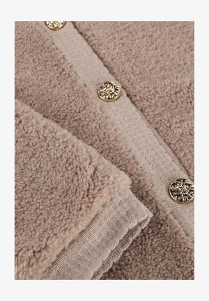 Beige fleece vest met een gestructureerde stof, voorzien van een gladde gebreide rand en gouden decoratieve knopen. Zacht, warm en gezellig ontwerp.