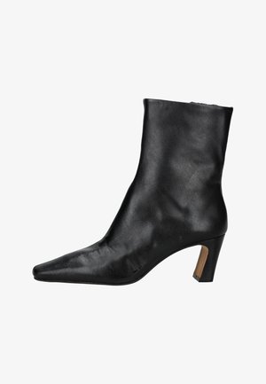 Zwart leren enkellaars met puntige neus en blokhak van gemiddelde hoogte, gladde textuur, zijritssluiting.