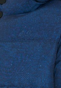 Giacca puffer in tessuto testurizzato blu con cucitura orizzontale e logo ricamato "St. Barth". Presenta chiusure a pulsante nere sul davanti.