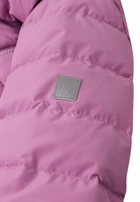 Giacca puffer in morbido tessuto lavanda con motivo trapuntato. Presenta un piccolo logo grigio sulla spalla e una texture liscia.