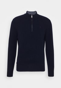 Granatowy sweter z zamkiem przy szyi wykonany z miękkiego dzianego materiału; posiada długie rękawy i ściągacz na dole, z minimalistycznym wzornictwem.