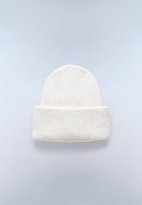 Gorro de punto blanco con una textura acanalada y un dobladillo. La tela parece suave y cálida, presentando un diseño simple y discreto.