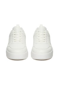 Par de zapatillas blancas de caña baja con cordones y suelas gruesas, mostradas desde el frente sobre un fondo blanco.