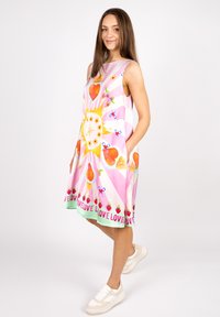 Ärmellos A-Linien-Kleid mit einem pink-weißen Muster, das Herzen, Blumen und Früchte akzentuiert; das Material ist leicht und glatt.