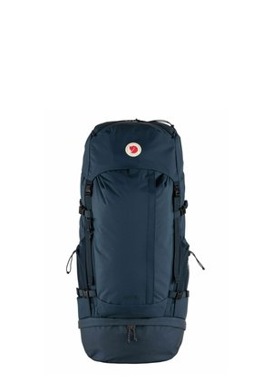 Dunkelblauer Rucksack aus strapazierfähigem Stoff; verfügt über verstellbare Träger, mehrere Fächer, ein rundes Logo-Patch und einen Kordelzugverschluss am Boden.