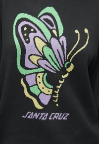 Sweater preto com um design de borboleta multicolorida em roxo, verde e amarelo, com o texto "SANTA CRUZ" em uma fonte estilizada abaixo.