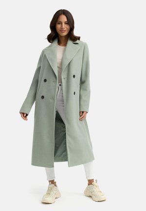 Double-breasted long coat in light green, made of textured fabric, with large black buttons, notched lapels, and side pockets.