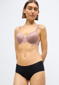 Svetloružová podprsenka s kostícami a nastaviteľnými ramienkami, doplnená čiernymi boyshort nohavičkami. Hladká látka so seamless dizajnom pre pohodlie.