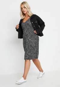 Mustavalkoinen kuvioitu bodycon-mekko, jossa on pyöreä pääntie, yhdistetty mustaan denimmihkutakkiin ja valkoisiin tennareihin. Sileä kangas.