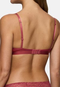 Braletka v hluboké růžové saténu s nastavitelnými ramínky a zapínáním na háček a oko. Hladký povrch a minimální kovové detaily na pásku.