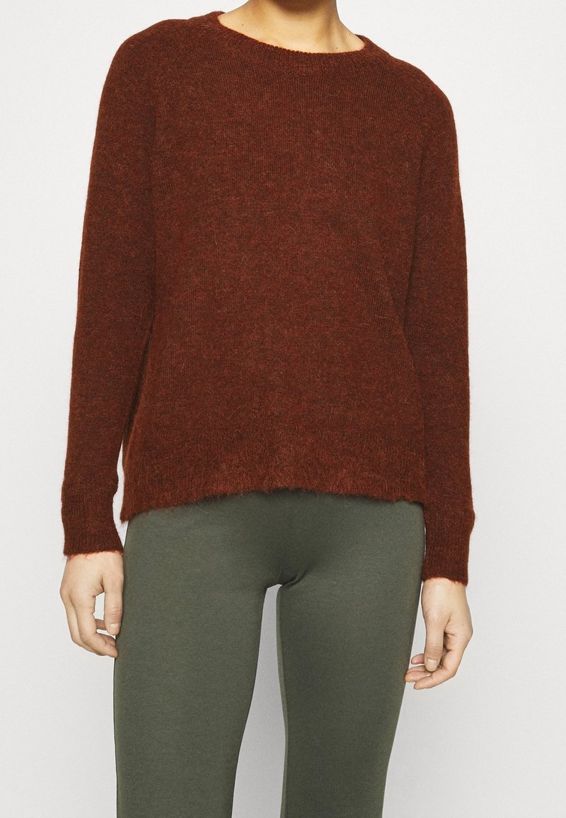 Pull tricoté bordeaux avec un col rond, des manches longues et un ourlet légèrement court. Le tissu semble doux et texturé.