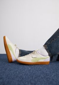 Puma sportcipők krémszínű, zöld és levendula színpalettával; velúr és textil anyagok; gumi talp; fűzős kialakítás.