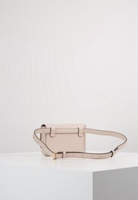 Bolso cruzado de cuero color beige claro con forma rectangular, correa ajustable y herrajes en tono dorado. Textura suave y diseño minimalista.