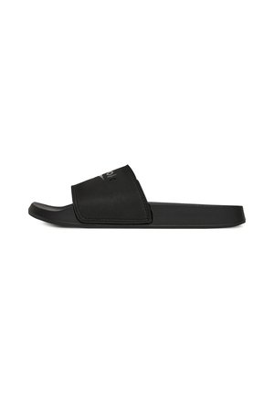 Sort slip-sandal med bred rem og formet fodseng, vist fra siden på hvid baggrund.