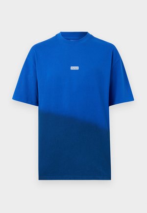 Blå kortermet t-skjorte med rund hals og en liten hvit rektangulær logo med teksten "HUGO" midt på brystet mot en ensfarget bakgrunn.