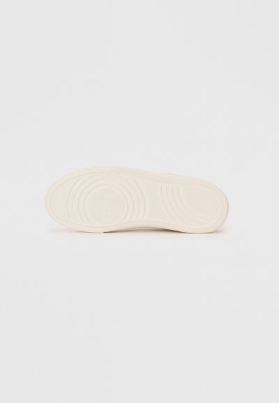 Shoe sole in light beige rubber with circular and wave patterns. Textured surface for grip, featuring brand name embossed.