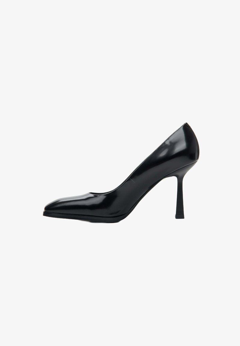 Czarny lakierowany but na wysokim obcasie z szpiczastym noskiem i smukłym obcasem typu stiletto, o gładkiej, błyszczącej powierzchni.