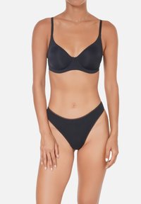 Soutien-gorge noir et string assorti, tous deux en tissu lisse. Le soutien-gorge présente des bretelles ajustables et des armatures, le string a une coupe taille basse.