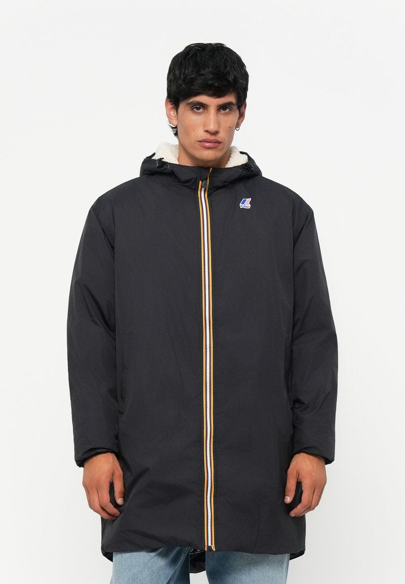 Black long jacket with a hood, featuring a yellow and white zipper detail and a logo on the chest. Fleece-lined interior for warmth.