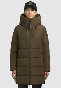 Oliven grøn pufferjakke med stor hætte, lynlåslukning, quilted design og to lynlåslommer på siderne. Har justerbare snore.