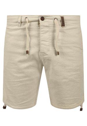 Beige shorts med dragsko i midjan, knappstängning, sidofickor och bruna läderdetaljer. Tillverkade av ett mjukt, strukturerat tyg.