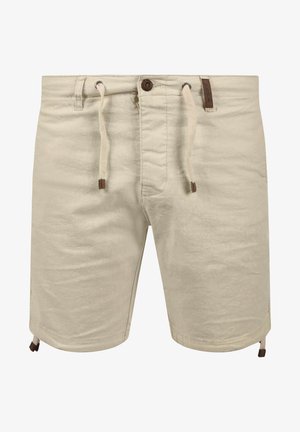 Beige shorts with a drawstring waist, a button closure, side pockets, and brown leather accents. Made of a soft, textured fabric.