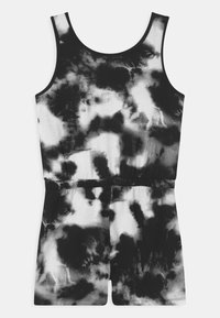 Czarny i biały kombinezon tie-dye o bezrękawowym kroju, okrągłym dekolcie, elastycznym pasie i krótkich nogawkach. Lekki materiał o miękkiej teksturze.