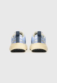 Et par lyseblå atletiske sneakers med beige såler, mørkeblå trekkremmer og reflekterende sølvstriper, vist fra baksiden på en hvit bakgrunn.