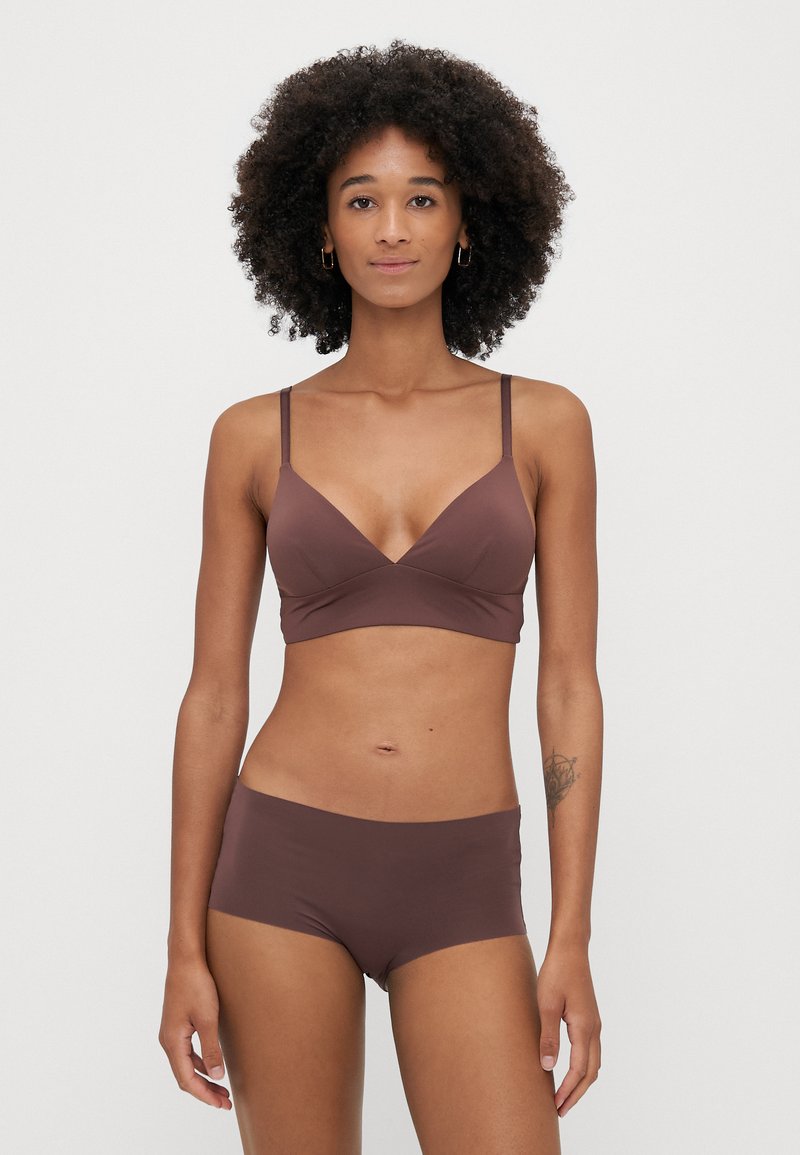 Ruskea bralette ja siihen sopivat hipster-shortsit, valmistettu sileästä kankaasta. Braletessa on V-pääntie ja ohuet olkaimet. Yksinkertainen muotoilu, ei kuvioita.
