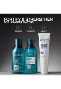 Redken Extreme Length Shampoo-, Conditioner- und Leave-in-Behandlungsflaschen mit Text, der die Haare in drei Schritten stärkt und festigt.