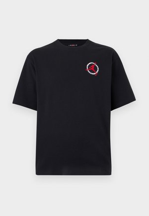 Μαύρη κοντομάνικη μπλούζα με μικρό κόκκινο λογότυπο Jumpman και κυκλικό σχέδιο στο αριστερό μέρος του στήθους.