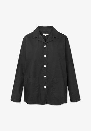 Chemise noire à manches longues en tissu léger. Dotée d'un col, de boutons blancs et de deux poches avant. Texture lisse, coupe droite.