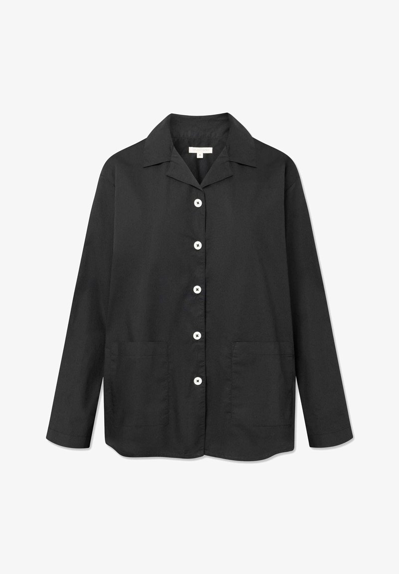 Chemise noire à manches longues en tissu léger. Dotée d'un col, de boutons blancs et de deux poches avant. Texture lisse, coupe droite.