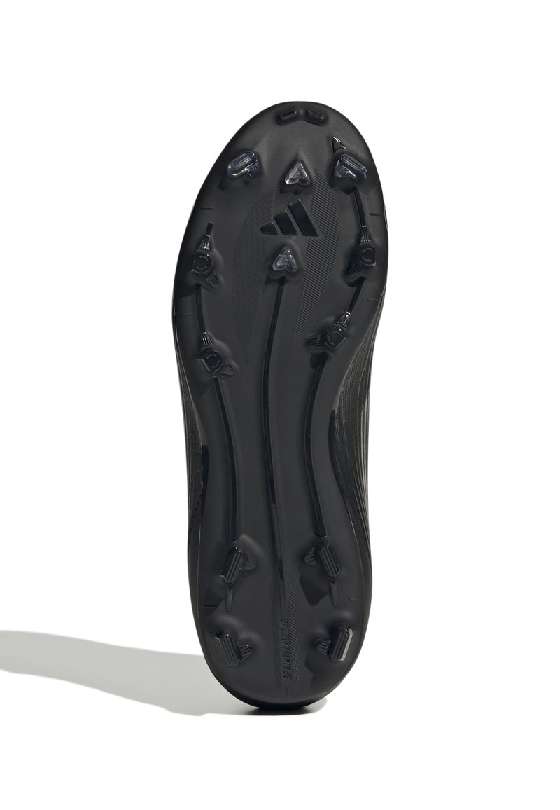 Suela de tacón negro para fútbol con taquitos alargados y características de tracción. Textura suave con un logotipo de marca visible cerca del talón.