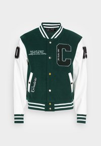 Giacca varsity verde e bianca con corpo in lana, maniche a contrasto, ricami e polsini e colletto a costine rigate. Dotata di bottoni a pressione.