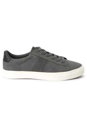 Basket basse grise avec languette de talon noire, fermeture à lacets à l’avant, détail perforé sur le côté et semelle en caoutchouc blanche.