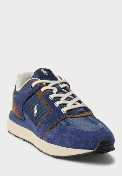 Adidași pentru bărbați cu un upper din plasă și suede de culoare albastru marin, accente bej, șireturi crem și o etichetă logo neagră pe limbă. Talpă din cauciuc.