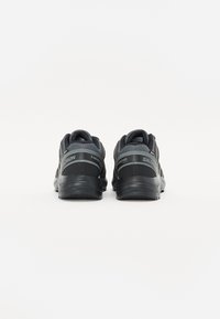 Czarne sportowe buty treningowe z teksturowanej siateczki i syntetycznego materiału, z amortyzującą podeszwą, wyściółką w okolicy kostki oraz szarymi akcentami.