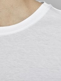 Camiseta de algodón blanca con diseño de cuello redondo, textura suave y costuras visibles alrededor del cuello.