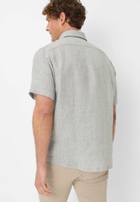 Hellgraues kurzärmliges Button-Up-Hemd aus strukturiertem Stoff mit Karomuster. Der Kragen ist klassisch, und die Rückseite verfügt über eine Schulterpasse.