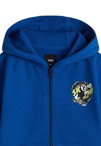 Sudadera azul con cremallera hecha de tela suave. Presenta un estampado gráfico de un logotipo de patinador y una gran capucha ajustable.