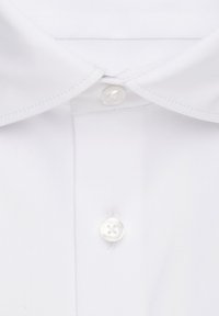 Camicia bianca con colletto classico, un pulsante tondeggiante e una texture di tessuto liscia.